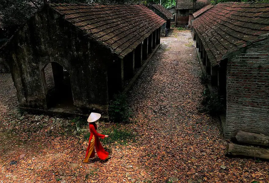 person woman walking houses huts wooden old village leaves