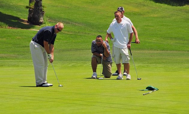 golfers golfing green putter putting caddy club ball course