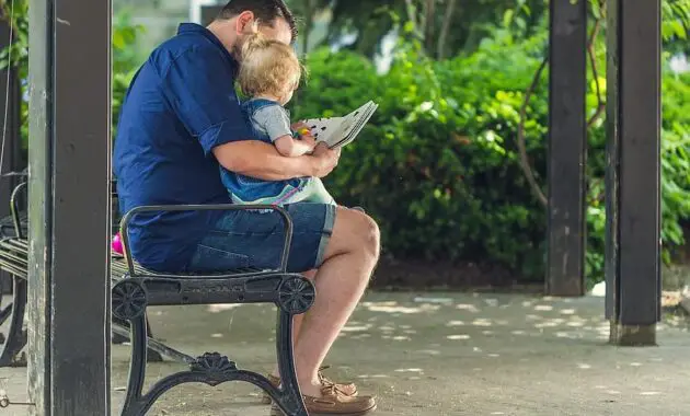 people father man reading book baby girl kid child