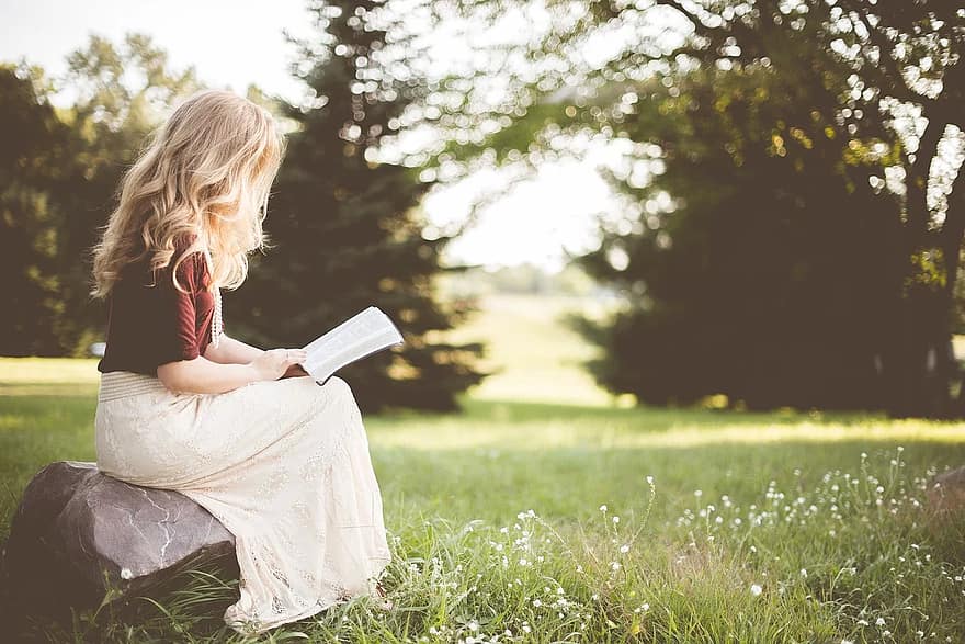 people girl alone sitting rock reading book bible nature