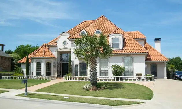 spanish style red brick tiles roof blue sky home house residence palm tree