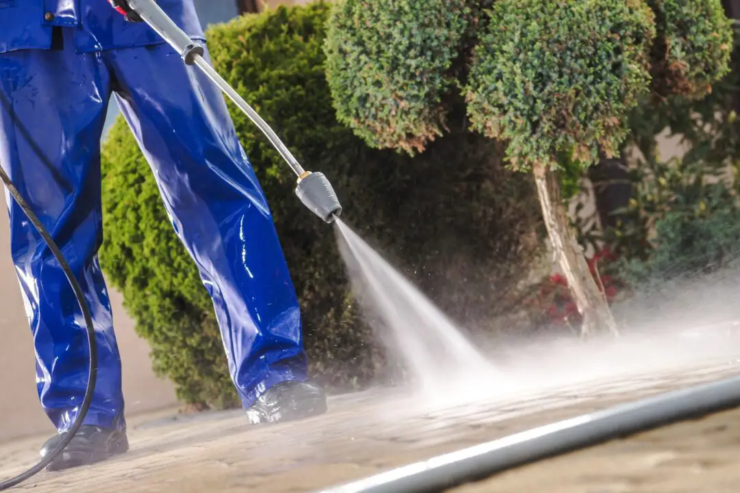 Men Washing Garden Residential Brick Paths With Professional Pressure Washer